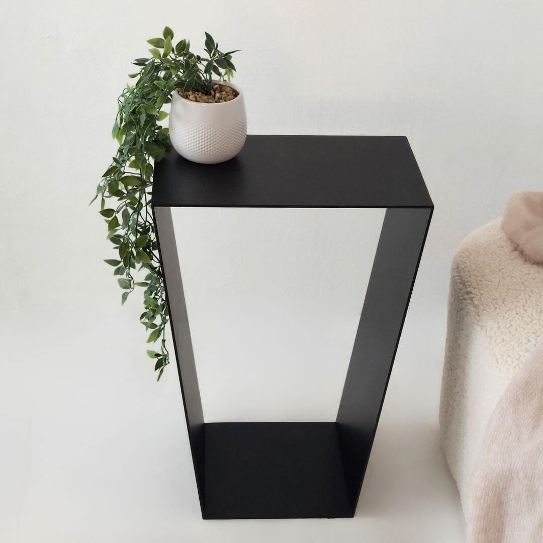 juodas žurnalinis staliukas prie sofos svetainėje